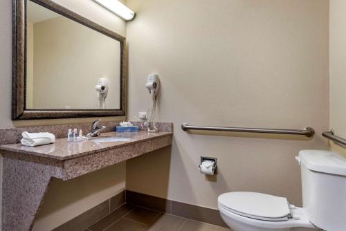 a bathroom with a toilet and a sink with a mirror at Comfort Inn & Suites Fort Walton Beach - Destin West in Fort Walton Beach