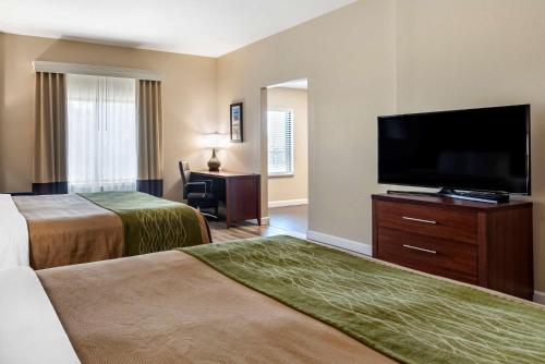 a hotel room with two beds and a flat screen tv at Comfort Inn & Suites Fort Walton Beach - Destin West in Fort Walton Beach