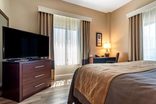 a hotel room with a flat screen tv and a bed at Comfort Inn & Suites Fort Walton Beach - Destin West in Fort Walton Beach