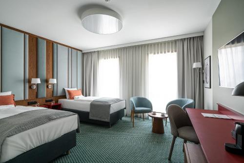 Pokój hotelowy z 2 łóżkami, biurkiem i krzesłami w obiekcie RentPlanet - Apartamenty Centrum we Wrocławiu