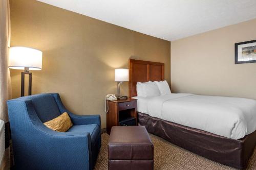 a hotel room with a bed and a chair at Comfort Inn & Suites Montpelier-Berlin in Montpelier