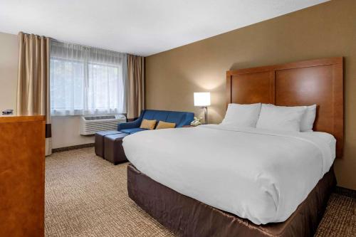 Comfort Inn & Suites Montpelier-Berlin في مونبلييه: سرير كبير وكرسي في غرفة الفندق