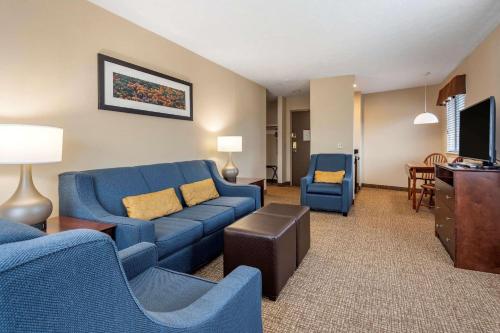 a living room with a blue couch and chairs at Comfort Inn & Suites Montpelier-Berlin in Montpelier