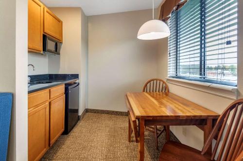 a kitchen with a wooden table and a dining room at Comfort Inn & Suites Montpelier-Berlin in Montpelier
