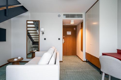 a living room with white furniture and a staircase at RentPlanet - Apartamenty Centrum in Wrocław