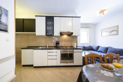 a kitchen and living room with a couch and a table at Apartment Tija in Dubrovnik