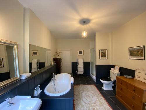 a bathroom with a tub and a sink and a toilet at Chillingham Manor in Chillingham