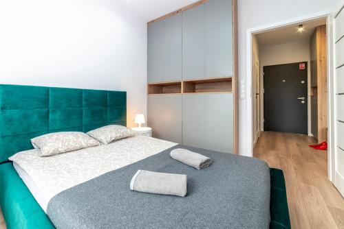 Un dormitorio con una cama grande con cabecero azul. en Apartamenty Przy IV Śluzie - Green, en Bydgoszcz