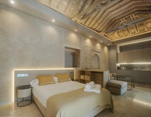 a bedroom with a large white bed in a room at Apartamentos Los Patios del Pañuelo in Córdoba