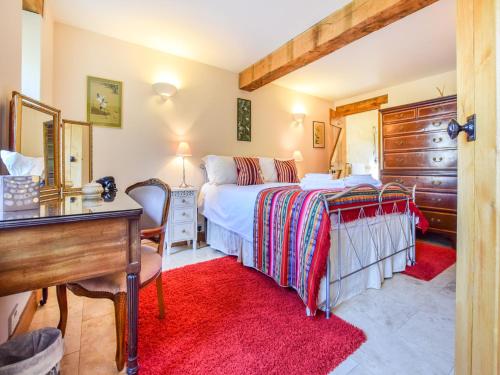 a bedroom with a bed and a desk and a desk at The Stables, Batheaston in Batheaston
