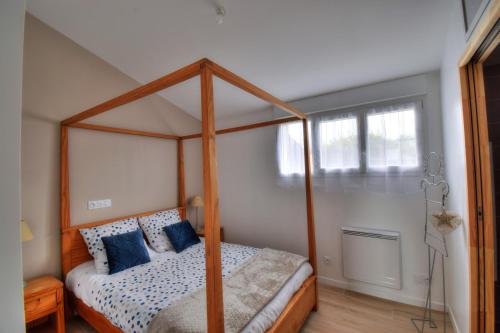 - une chambre avec un lit à baldaquin et des oreillers bleus dans l'établissement La vie en rose, à Ploubezre