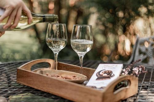a bottle of wine being poured into two wine glasses at Linvale Country Lodge in Hazyview