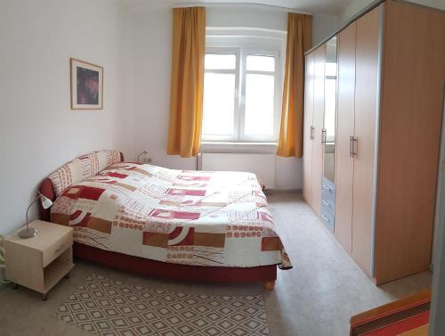 a bedroom with a bed and a window at Ferienwohnungen Stricker in Bad Muskau