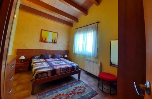 1 dormitorio con cama y taburete rojo en Xalet piscina privada Ibiscus en L'Ametlla de Mar