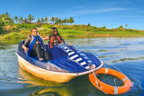 a man and woman in a boat on the water at Anchaviyo Resort in Vāda