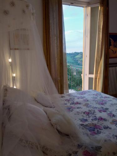 a bedroom with a bed and a window with a view at B&B Palazzo Mestichelli Boutique Palace in Monteprandone