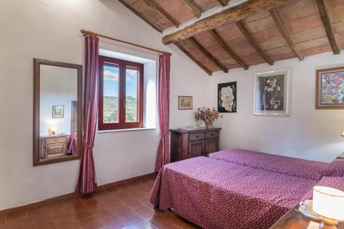 1 dormitorio con cama morada y ventana en PODERE SAN ANSANO 14&2, Emma Villas, en Paganico