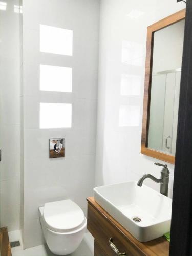 a bathroom with a toilet and a sink and a mirror at Cozy Apartment In Ortacahala in Tbilisi City