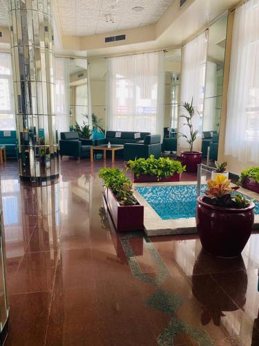a lobby with plants and a pool in the middle at Basma Residence Hotel Apartments in Sharjah