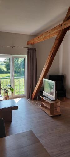 sala de estar con TV sobre una mesa de madera en Ferienwohnung Matzibarg, en Ahrenviöl