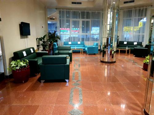 a lobby with blue couches and chairs in a building at Basma Residence Hotel Apartments in Sharjah