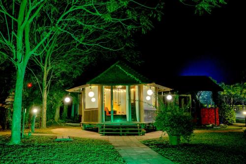 a tiny house in the middle of a yard at night at Anchaviyo Resort in Vāda