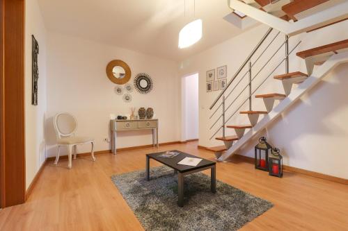 a living room with a table and stairs at Janela Mar Golden in Lagoa