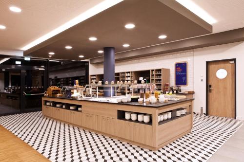 a restaurant with a counter in a room at Holiday Inn Express - Lustenau in Lustenau