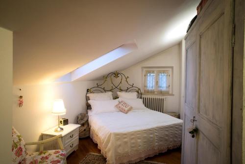 a bedroom with a white bed with a light on it at B&B Palazzo Mestichelli Boutique Palace in Monteprandone
