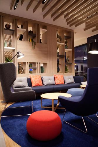 a living room with couches and a red ball on a blue rug at Holiday Inn Express - Lustenau in Lustenau