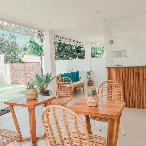 a dining room with wicker chairs and a wooden table at Pineale Villas, Resort and Spa in Panglao