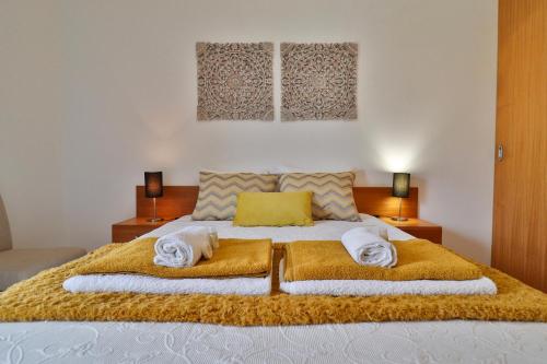 1 dormitorio con 1 cama grande y toallas. en Janela Mar Golden, en Lagoa
