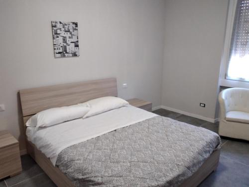 1 dormitorio con 1 cama grande y 1 silla en casa serrati(locanda la cascina)camera con bagno privato ma cucina in comune, en San Giuliano Milanese