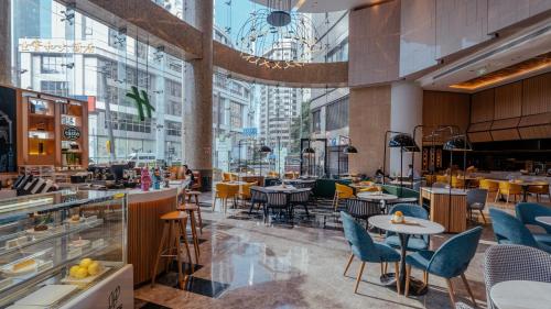 a restaurant with tables and chairs in a building at Holiday Inn Shanghai Nanjing Road by IHG in Shanghai
