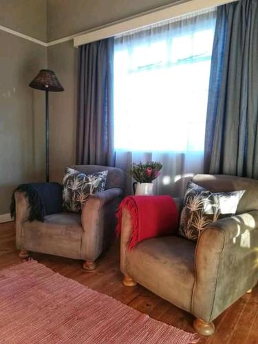 a living room with two couches and a large window at Die Pophuis in Aberdeen