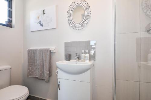 a bathroom with a sink and a toilet and a mirror at Hip-Nautic in Yzerfontein