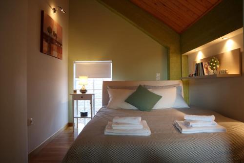 een slaapkamer met een bed met handdoeken erop bij Dream Mountain House in Kalavrita