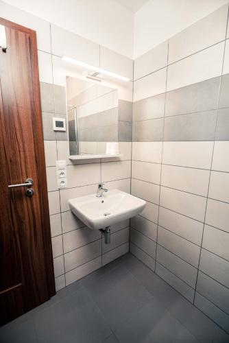 a white bathroom with a sink and a mirror at Penzion Třetí frejd in Bořetice