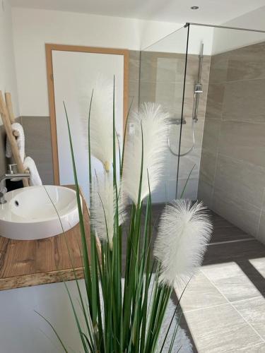 łazienka z prysznicem, umywalką i rośliną w obiekcie Naturpark Appartment w mieście Großsölk