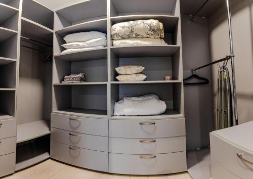 ein begehbarer Kleiderschrank mit weißen Schubladen in der Unterkunft Vintage Apartments in Odessa
