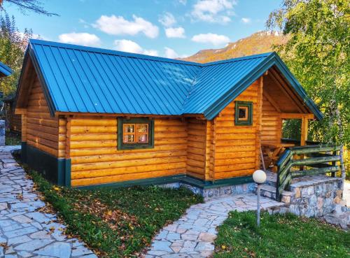 a log cabin with a blue roof at KOZAK Apartments & Restaurant in Mojkovac