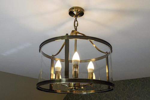 a brass and glass chandelier hanging from a ceiling at Dunnet B&B Escapes in Dunnet