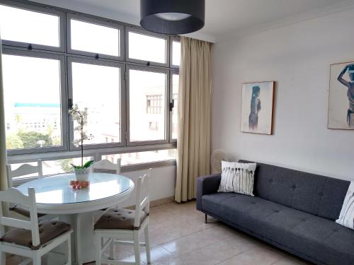 ein Wohnzimmer mit einer Couch und einem Tisch in der Unterkunft Sweet Home Las Canteras in Las Palmas de Gran Canaria