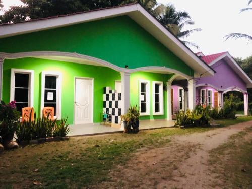 a house painted in green and pink at D'BERJAYA HOMESTAY & ROOMSTAY in Pantai Cenang