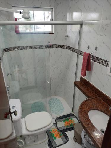 a bathroom with a shower and a toilet and a sink at Apartamento VISTA MAR - Condomínio Granito e Jasmim in Jacumã