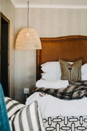 a bed with a wooden headboard and pillows at Twyfelberg Karoo Hideaway in Britstown