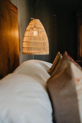 a bedroom with a bed with a lamp and a pillow at Twyfelberg Karoo Hideaway in Britstown