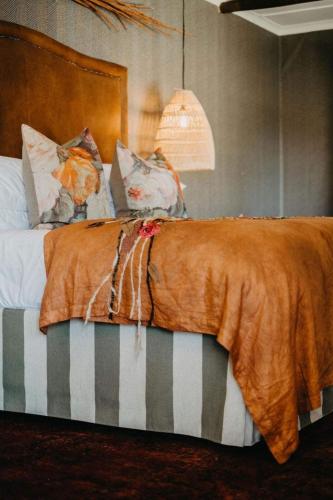 a bed with a brown blanket on top of it at Twyfelberg Karoo Hideaway in Britstown