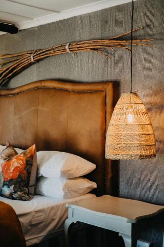 a bed with a headboard and a lamp and a table at Twyfelberg Karoo Hideaway in Britstown