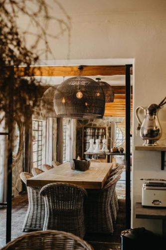 a dining room with a table with wicker chairs at Twyfelberg Karoo Hideaway in Britstown